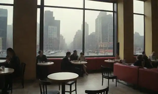 1920s-30s paisaje urbano con figuras vanguardistas en una cafetería, formas y líneas abstractas, siluetas fragmentadas de edificios, colores atrevidos e instalaciones de arte modernas