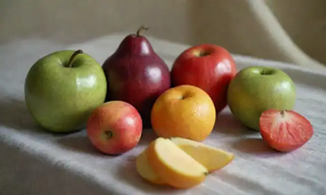 formas 3D, formas fragmentadas, colores mudos, composición de la vida, fruta y verduras, mantel con pliegues sutiles, fondo de enfoque suave, iluminación cálida, sombras simples