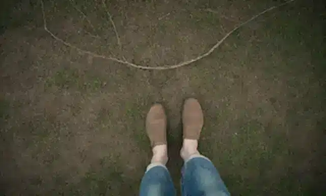 Una persona de pie sobre un parche de hierba