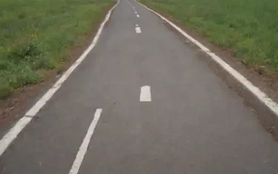 Una persona de pie en un tenedor en el camino con dos caminos que se extienden a la distancia