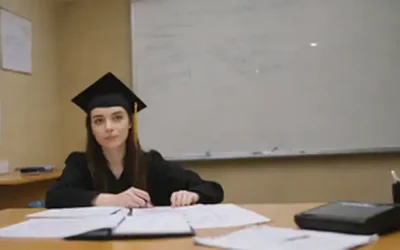 Un estudiante sentado en un escritorio con libros y papeles esparcidos alrededor