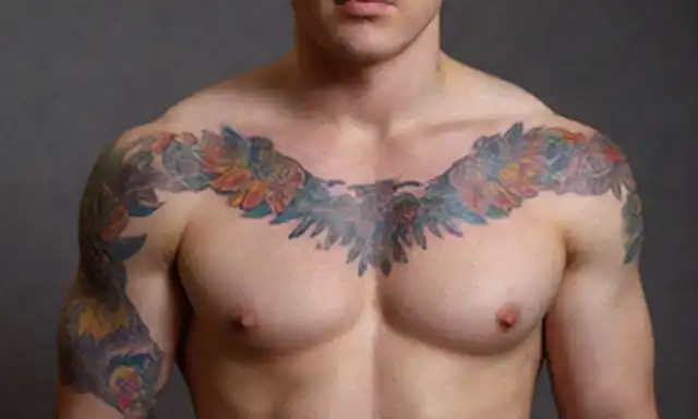 Una persona con un diseño de tatuaje audaz y colorido en su brazo o pecho; patrones intrincados y formas que se mezclan para crear una narrativa visual; simbolismo tejido a lo largo de todo