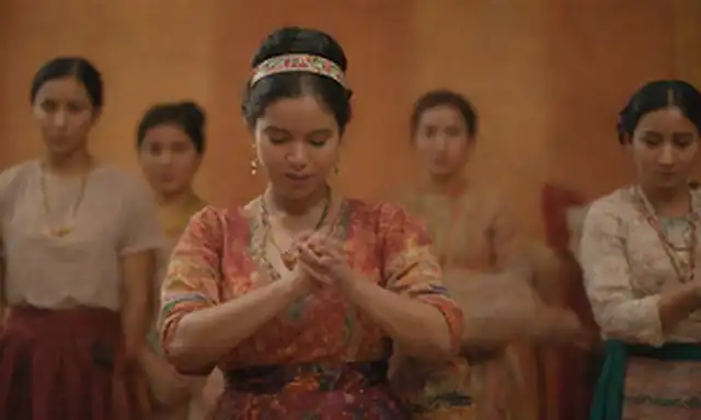Un grupo diverso de personas, colores vibrantes, atuendo tradicional, símbolos culturales, textiles tejidos, instrumentos musicales, poses de baile popular, manos que sostienen objetos de significado, iluminación cálida, enfoque suave, textura sutil de fondo, composición atractiva, ambiente inclusivo