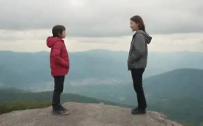 Una persona reflexiva de pie sobre un pico de montaña
